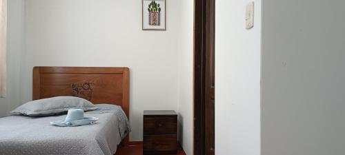a bedroom with a bed with a wooden headboard at Hospedaje Vacacional - Colca in Chivay