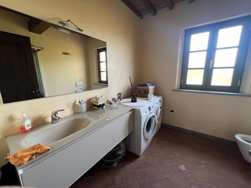 a bathroom with a sink and a washing machine at Villa Cerretina in Cerreto Guidi