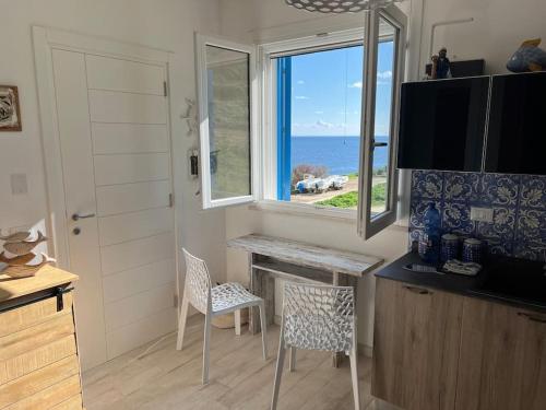uma pequena cozinha com uma mesa e uma janela em Isola di Marettimo casa vacanze em Marettimo