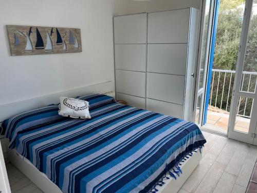 a bedroom with a bed with a striped blanket at Isola di Marettimo casa vacanze in Marettimo