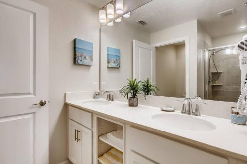 een badkamer met 2 wastafels en een grote spiegel bij Storey Lake Resort Near Disney Universal in Kissimmee