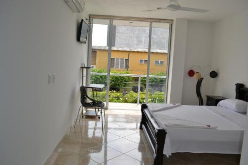 1 dormitorio con cama y ventana grande en hotel brasil, en Puerto Boyacá