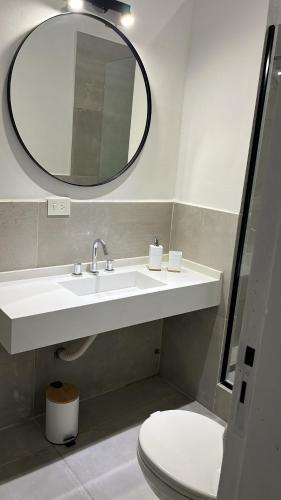 a bathroom with a sink and a mirror and a toilet at La Abundancia Capilla del Senor in Capilla del Señor