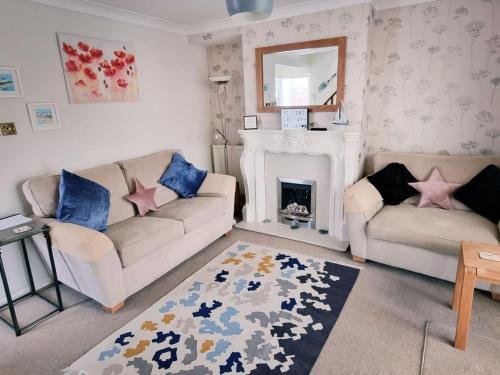 ein Wohnzimmer mit 2 Sofas und einem Kamin in der Unterkunft Sunny Queens Park Home - Garden & Private Parking in Brighton & Hove