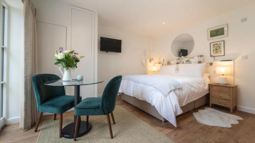 a bedroom with a bed and a table and chairs at The Garden Room - 1 bedroom annex in Penrith in Penrith