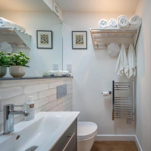 a white bathroom with a sink and a toilet at The Garden Room - 1 bedroom annex in Penrith in Penrith