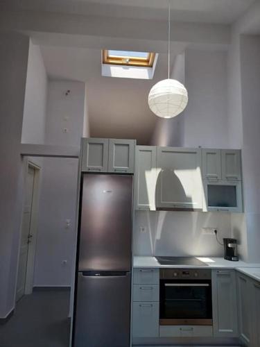 a kitchen with a stainless steel refrigerator and a light at Aspa's house in Myrina