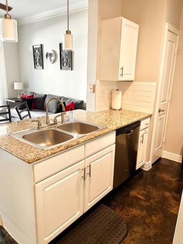 uma cozinha com um lavatório e uma sala de estar em Luxe Lavish w/ Pool em Houston