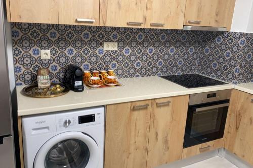 een keuken met een wasmachine en een fornuis bij Enna House 1 in Athene