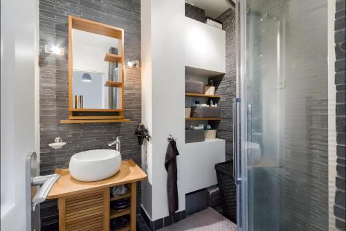 une salle de bain avec un lavabo et un miroir dans l'établissement Appartement 2 pièces avec vue Tour Eiffel, à Paris