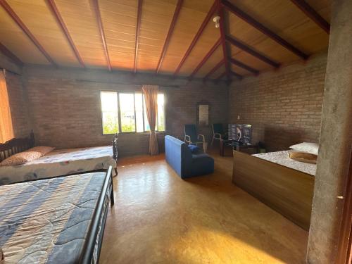 Habitación con 2 camas y sofá. en Casa Campestre Lago Calima, en Calima