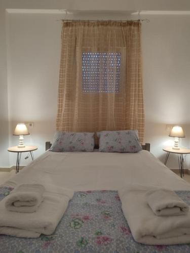 a bedroom with a large bed with two tables at Creta Irini's Rooms2 in Tympáki