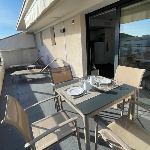 une table et des chaises assises sur un balcon avec une table et des chaises dans l'établissement Top Floor Secret Garden, Cannes, à Cannes