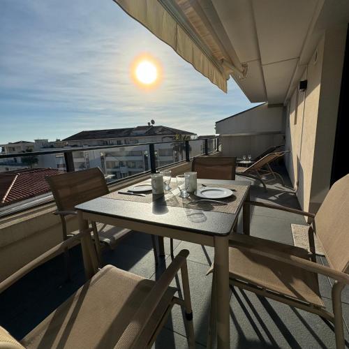 d'un balcon sur le toit avec une table et des chaises. dans l'établissement Top Floor Secret Garden, Cannes, à Cannes