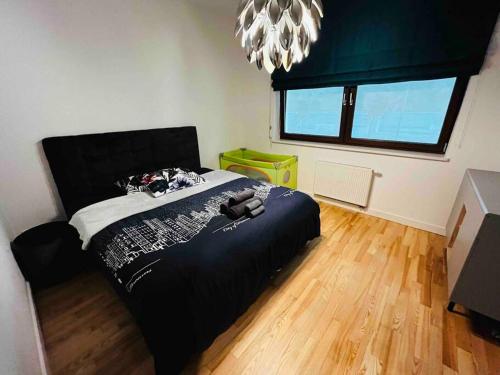 a bedroom with a black bed in a room at Komfortowy apartament z siłownią i sauną Revisit Apartment 11 in Łódź