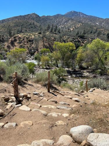 een rotsachtig veld met bomen en bergen op de achtergrond bij SoCal Camping in Kernville