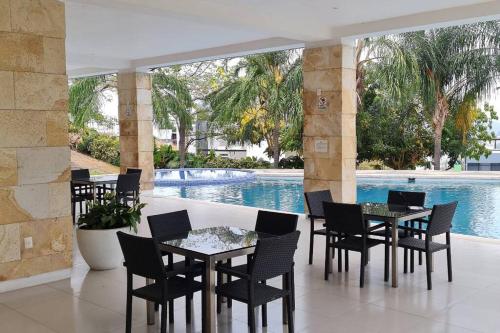 a patio with tables and chairs next to a pool at Residencia Corinto La Cima Frac Burgos Bugambilias in Temixco