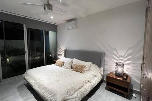a bedroom with a large bed and a night stand at Residencia Corinto La Cima Frac Burgos Bugambilias in Temixco