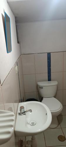 a bathroom with a white sink and a toilet at Hospedaje Vacacional - Colca in Chivay