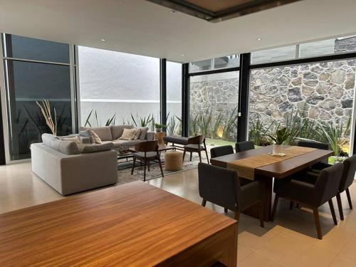 a living room with a couch and a table and chairs at Residencia Corinto La Cima Frac Burgos Bugambilias in Temixco