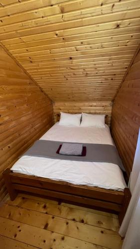 a bed in a wooden room in a cabin at Порядна Ґаздиня in Yaremche