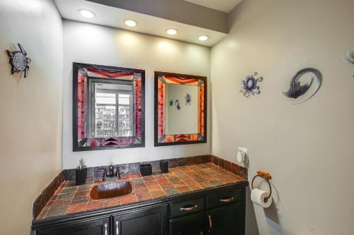 a bathroom with a sink and two mirrors at Waterfront Long Beach Condo with Pool Access! in Long Beach