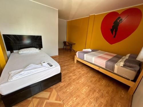 1 dormitorio con 1 cama y un corazón en la pared en LOS PECANOS en Ica