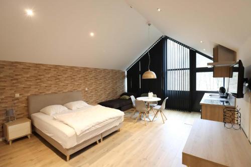 1 dormitorio con cama y pared de ladrillo en Recreatiedomein Warredal - The Lodge, en Neeroeteren