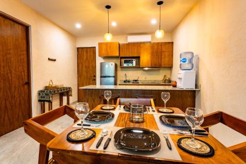 a kitchen with a wooden table with wine glasses on it at MICAELA apartment pool AC next to the lagoon in Bacalar
