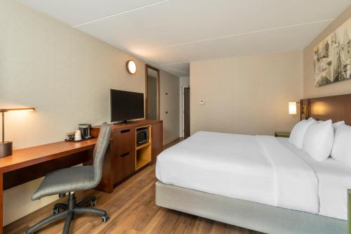 a hotel room with a bed and a desk at Comfort Inn East in Sudbury