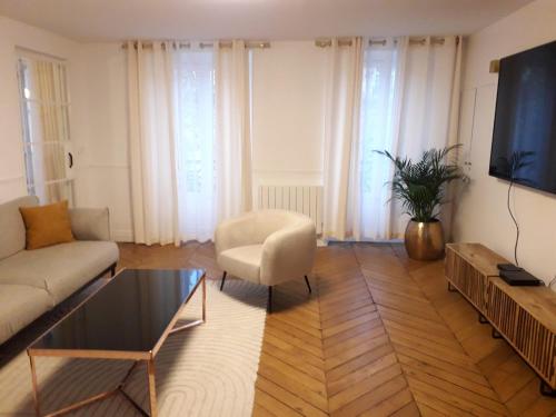 un salon avec un canapé et une télévision dans l'établissement Champs Elysées Luxury appartment, à Paris