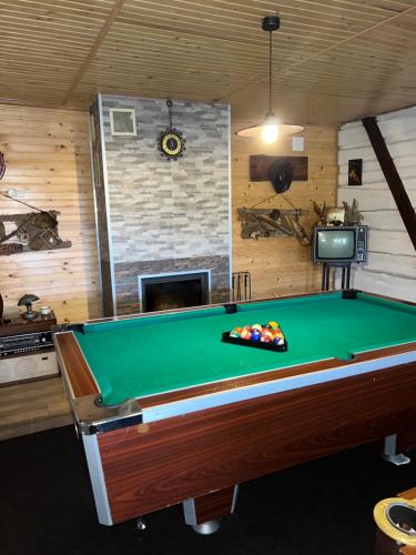 a pool table in a room with a fireplace at Порядна Ґаздиня in Yaremche