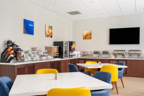 a dining room with tables and chairs and a flat screen tv at Comfort Inn & Suites Danbury-Bethel in Danbury