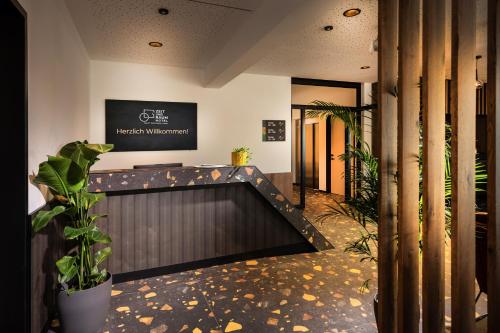 a lobby with a reception desk and plants at Zeit und Raum Hotel - Self Check-In in Eggelsberg