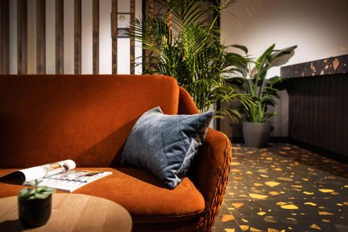 Zeit und Raum Hotel - Self Check-In في Eggelsberg: كرسي برتقالي مع وسادة زرقاء وطاولة