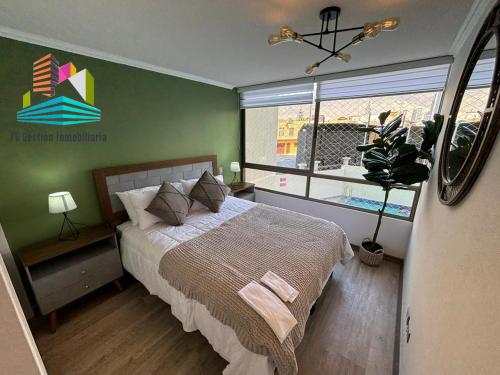 een slaapkamer met een bed en een groot raam bij NUEVO E IMPECABLE A PASOS DEL MAR in Antofagasta