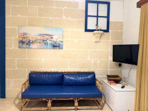 un sofá azul frente a una pared de ladrillo en Paradise 1 en Żebbuġ
