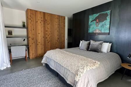 1 dormitorio con 1 cama grande y armario de madera en 45 Degrees South BBQ Hot TubPrivate, en Queenstown