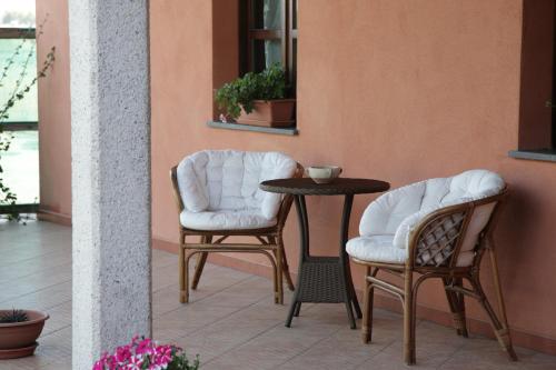 two chairs and a table on a patio at CuccuruAio' B&B in Siamaggiore