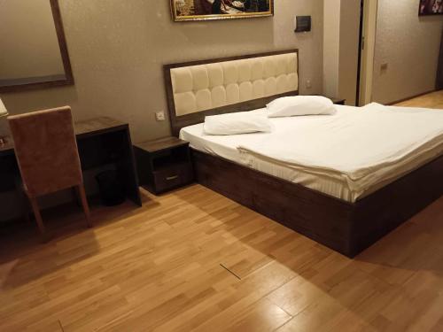 a bedroom with a bed and a table and a chair at soprano guest house in Baku