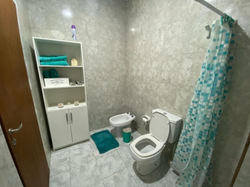 uma casa de banho com um WC e uma cortina de chuveiro azul em LU DORMIS Alquiler Temporario em Corrientes