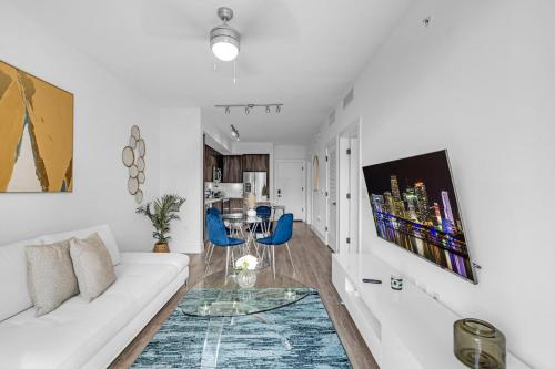 - un salon blanc avec un canapé blanc et des fauteuils bleus dans l'établissement Sleek Doral Retreat 1 Bed Oasis With Free Parking, à Hialeah Gardens