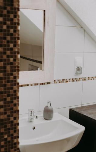 a bathroom with a white sink and a mirror at Domowe Pielesze in Olszanica
