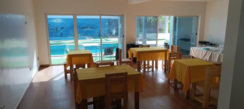 a dining room with tables and chairs and a pool at Espaço-Vila Verde 