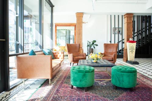 a living room with couches and chairs and a table at 11th Avenue Hostel in Denver