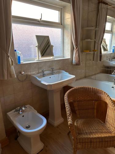 een badkamer met een wastafel, een toilet en een raam bij Lowry House Hotel in Great Barr in Birmingham