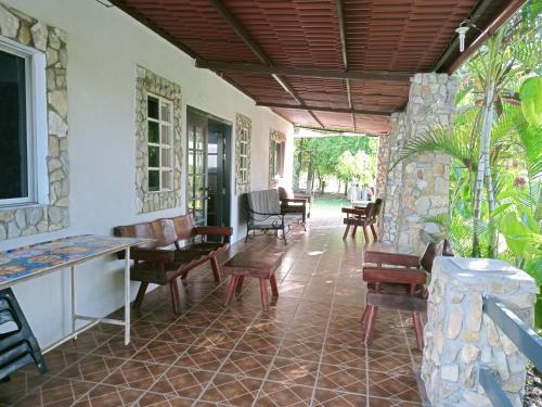 a porch of a house with chairs and tables at Quinta Nova Sky in Tamasopo