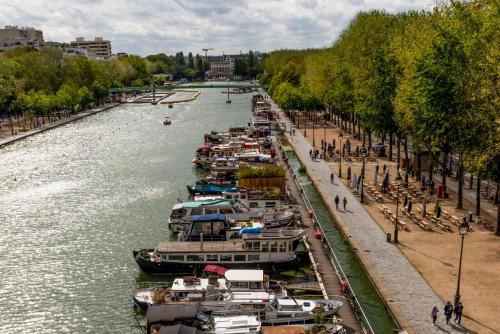 a group of boats are docked in a river at Holiday Inn Express Paris-Canal De La Villette by IHG in Paris