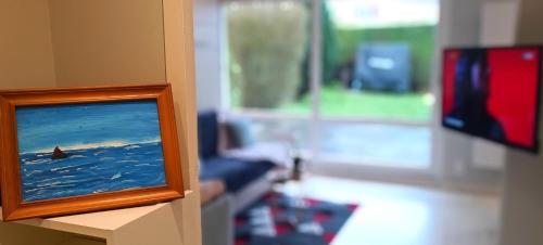 a picture of a television in a living room at Studio proche plage - Parking gratuit et privé - Terrasse et petit jardin clôturé in Courseulles-sur-Mer