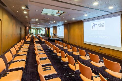 a lecture hall with chairs and a projection screen at Holiday Inn Express Paris-Canal De La Villette by IHG in Paris